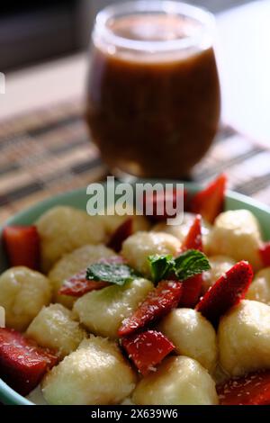 Délicieux boulettes paresseuses avec des baies, de la crème sure, des feuilles de menthe et un smoothie rouge sur une table en bois. Parfait pour les projets culinaires, liés à la nourriture Banque D'Images