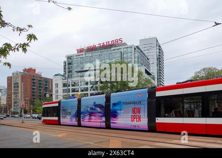 Toronto Street car sur le boulevard Lakeshore, devant le Tip Top Tailors Building, maintenant connu sous le nom de « Tip Top Lofts », est un ancien bâtiment industriel des années 1920 Banque D'Images