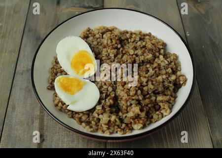 Bouillie de sarrasin avec oeuf dur coupé dans un bol. Nourriture saine. Traditions slaves du plat. Banque D'Images