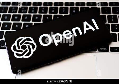 Smartphone avec logo OpenAI sur MacBook Keyboard. Symbolisant la technologie IA de pointe. Stafford, Royaume-Uni, 28 avril 2024 Banque D'Images