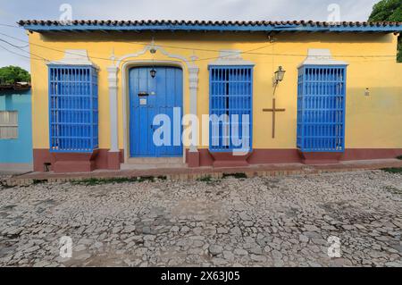 272 façade de couleur jaune de la maison coloniale avec portes principales en bois bleu et guichet et grilles tournées, Calle Amargura Street numéro 108. Trinidad-Cuba. Banque D'Images