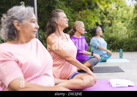 Diverses amies seniors pratiquant le yoga en extérieur Banque D'Images