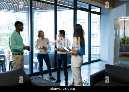 Équipe diversifiée discutant dans un espace de bureau moderne Banque D'Images