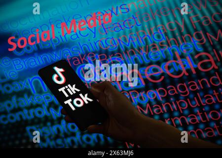 Bruxelles, Belgique. 12 mai 2024. Le logo TikTok est affiché sur un smartphone avec médias sociaux - mot de désinformation visible en arrière-plan sur cette illustration photo. Prise à Bruxelles, Belgique. Le 12 mai 2024. (Jonathan Raa/Sipa USA) *** strictement à des fins éditoriales *** crédit : Sipa USA/Alamy Live News Banque D'Images