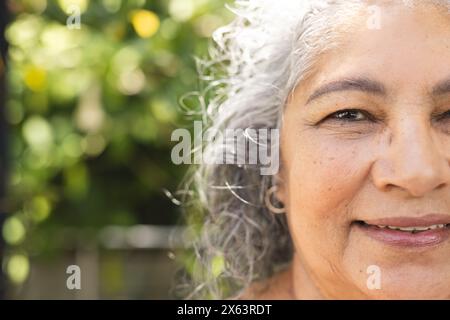 À l'extérieur, femme biraciale senior avec les cheveux gris souriant, espace de copie Banque D'Images