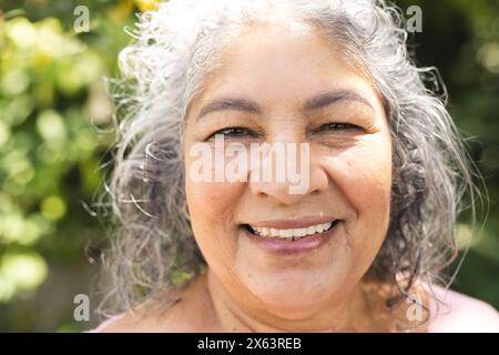 Dehors, femme biraciale senior avec les cheveux gris souriant Banque D'Images