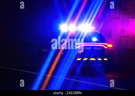 Voiture de police d'État avec feux de détresse clignotants la nuit Banque D'Images