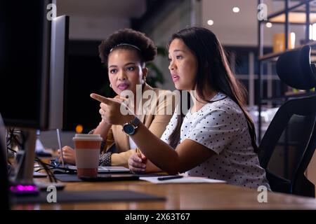 Diverses collègues féminines travaillant tard au bureau Banque D'Images