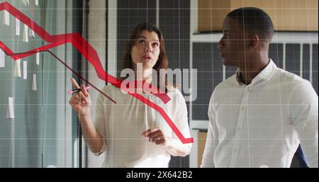 Image de graphiques rouges se déplaçant au-dessus de divers hommes et femmes discutant au-dessus de notes de mémo au bureau Banque D'Images