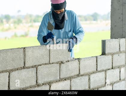 Un maçon installant des briques de dortoir sur le chantier de construction Banque D'Images