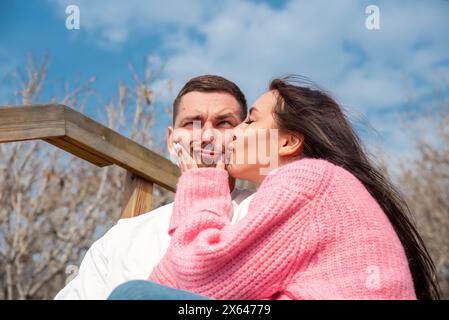 Portrait drôle de jeune couple russe marié, femme embrassant son mari mais il fait un visage drôle Banque D'Images