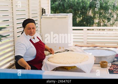 Femme préparant le pain plat traditionnel dans le marché extérieur pendant la journée Banque D'Images