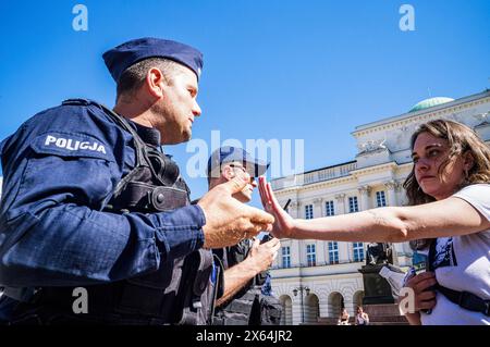 Varsovie, Pologne. 12 mai 2024. Un manifestant garde la police à distance de bras. Alors qu'une vague de manifestations pro-palestiniennes balaye le monde, des centaines de personnes à Varsovie, en Pologne, sont descendues dans les rues le 12 mai pour commémorer les victimes de la Nakba en 1948 ainsi que les 34 000 personnes assassinées en Palestine depuis octobre. Au soleil, la manifestation Varsovian marche de l'historique Plac Zamkowy à l'ambassade américaine, en s'arrêtant au palais présidentiel. Crédit : SOPA images Limited/Alamy Live News Banque D'Images