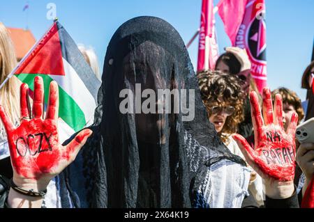 Un manifestant, les mains rouges avec du faux sang, montre un message écrit en polonais, la traduction anglaise est "Eyes on Rafah" pendant le rassemblement. Alors qu'une vague de manifestations pro-palestiniennes balaye le monde, des centaines de personnes à Varsovie, en Pologne, sont descendues dans les rues le 12 mai pour commémorer les victimes de la Nakba en 1948 ainsi que les 34 000 personnes assassinées en Palestine depuis octobre. Au soleil, la manifestation Varsovian marche de l'historique Plac Zamkowy à l'ambassade américaine, en s'arrêtant au palais présidentiel. (Photo de Neil Milton/SOPA images/SIPA USA) Banque D'Images