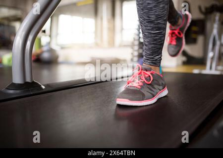 Gros plan des jambes de la femme de sport dans le gymnase. Entraînement de routine pour la santé physique et mentale de la femme. Banque D'Images