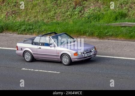 Années 1989 80 années 80 Rose Ford Escort Xr3i convertible. MK4 Escort Cabriolet voyageant sur l'autoroute M61 Royaume-Uni Banque D'Images