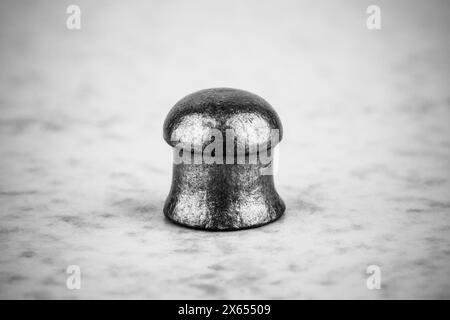 balle en plomb pour pistolets à air sur un fond gris gros plan, photo noir et blanc Banque D'Images