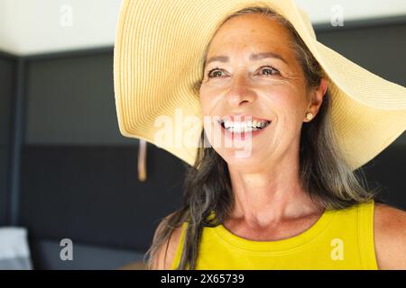 À la maison, femme caucasienne mature portant un chapeau de soleil souriant Banque D'Images