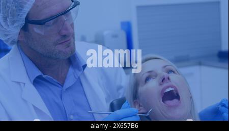 Image d'icônes de pizza sur le dentiste masculin caucasien traitant une femme caucasienne Banque D'Images