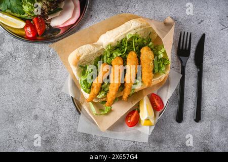 Crevettes frites dans du pain avec des légumes verts sur le côté. Sandwich aux crevettes Banque D'Images