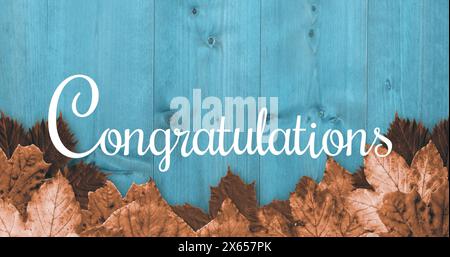 Feuilles brunes sur bois bleu avec Félicitations écrites Banque D'Images