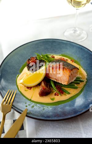 Filet de saumon avec sauce crémeuse, quinoa et légumes sur une assiette, repas savoureux Banque D'Images