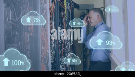 Image de nuages avec des nombres croissants sur un homme caucasien stressé debout devant des serveurs Banque D'Images