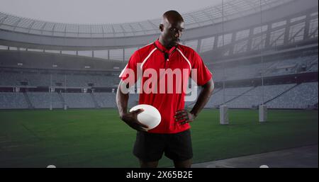 Image d'un joueur masculin afro-américain de rugby avec balle au-dessus du stade Banque D'Images