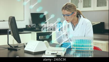 Image d'un brin d'adn au-dessus d'une femme caucasienne médecin en laboratoire Banque D'Images