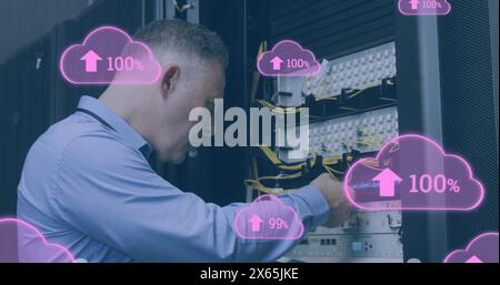 Image de nuages avec un nombre croissant d'hommes caucasiens travaillant dans la salle des serveurs Banque D'Images