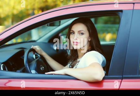 Portrait d'une femme conductrice souriante heureuse assise derrière le volant de la voiture Banque D'Images