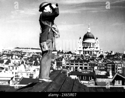 Homme scannant le ciel pour les avions allemands, Londres, Royaume-Uni des années 1940 Banque D'Images