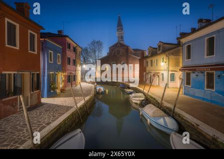 Campanile penché et maisons colorées reflétées à l'heure bleue de Burano Banque D'Images