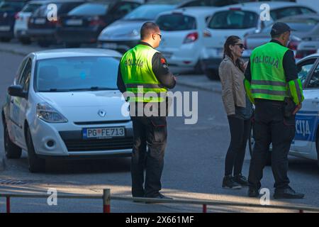 Podgorica, Monténégro - 20 avril 2019 : deux policiers (Policija) discutent avec une femme près de leur voiture. Banque D'Images