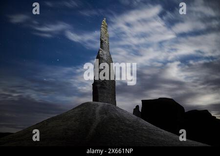 Une flèche solitaire illuminée la nuit lors d'un lever de lune lumineux. Banque D'Images