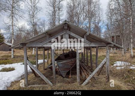 Un vieux bateau à rames sous une canopée par temps nuageux de printemps. Banque D'Images