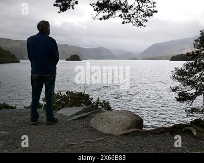 Un homme en silhouette profitant de la vue de Derwentwater depuis Friar's Crag, près de Keswick. Lake District, Cumbria, Royaume-Uni Banque D'Images