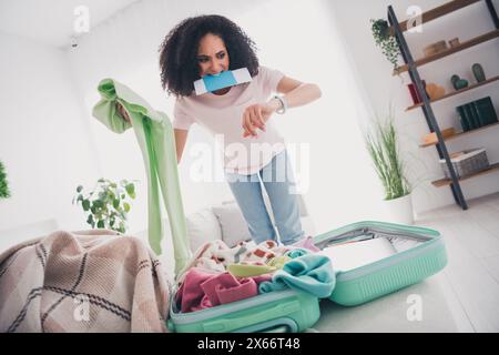 Photo d'une fille mignonne déprimée folle stressée se pressant à l'aéroport mettant des vêtements préparant le week-end voyage Resort Banque D'Images