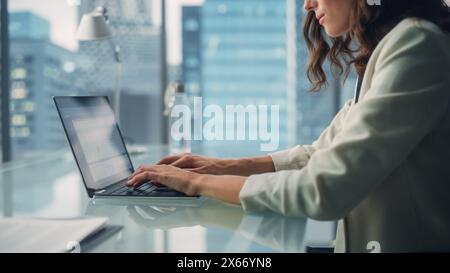 Portrait de jeune femme d'affaires caucasienne réussie assise au bureau travaillant sur ordinateur portable dans le bureau de la ville. Belle et talentueuse directrice générale Plan Stratégie de médias sociaux pour le projet de commerce électronique Banque D'Images