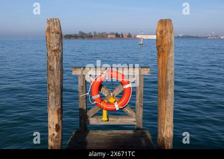 Ceinture de sauvetage avec corde et lampe au bout d'un quai dans la lagune vénitienne à Venise, Italie. Banque D'Images