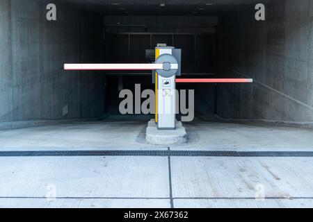Barrières automatiques à l'entrée de l'aire de stationnement. Entrée du parking souterrain. Bâtiment moderne en béton. Banque D'Images