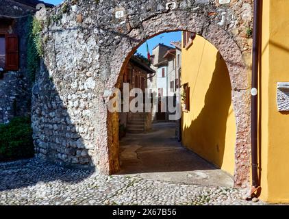 Porte historique en arc de brique dans l'étroite ruelle de la petite ville italienne Malcesine sur le lac de Garde Banque D'Images