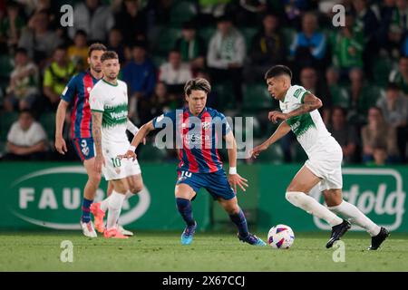 Elche, Espagne. 13 mai 2024. ELCHE, ESPAGNE - 12 MAI : Nico Castro attaquant le milieu de terrain de l'Elche CF concourt pour le ballon avec Kento Hashimoto milieu de terrain défensif de SD Huesca lors du match LaLiga Hypermotion entre l'Elche CF et le SD Huesca au stade Manuel Martinez Valero, le 12 mai 2024 à Elche, Alicante, Espagne. (Photo de Francisco Macia/photo Players images) crédit : Magara Press SL/Alamy Live News Banque D'Images