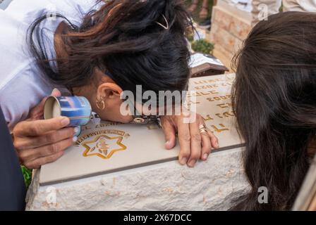 Ashkelon, Israël. 13 mai 2024. La mère (l) du sergent Oriya Yaakov, 20 ans, qui a été tué dans les combats dans la bande de Gaza, pleure sa tombe dans le cimetière d'Ashkelon alors qu'Israël célèbre le jour du souvenir le 13 mai 2024. Le sergent Yaakov a été tué le jour de son anniversaire selon le calendrier hébreu. Photo de Jim Hollander/UPI crédit : UPI/Alamy Live News Banque D'Images