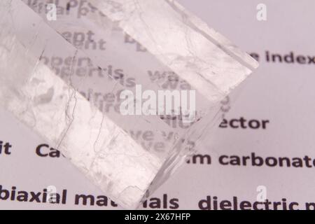 Biréfringence optique démontrée à l'aide d'un texte à l'aide d'un cristal de calcite double espar naturel, d'un plan macro et d'ombres réelles Banque D'Images