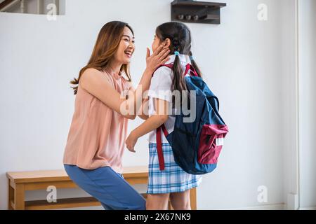 mère embrassant sa fille disant Au revoir avant d'aller à l'école à la maison Banque D'Images