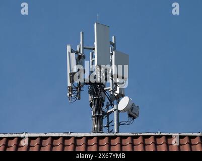 Berlin, Allemagne. 31 mars 2024. Un mât avec antennes de téléphone portable est monté sur le toit d'une maison. Crédit : Soeren Stache/dpa/Alamy Live News Banque D'Images