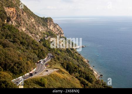 Mer bleue et montagnes vertes contre le ciel bleu. Route de montagne serpentine. Budva. Un voilier et un yacht sur la mer Adriatique. Printemps et été Banque D'Images