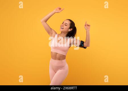 Joyeuse jeune femme célébrant une victoire en vêtements athlétiques Banque D'Images