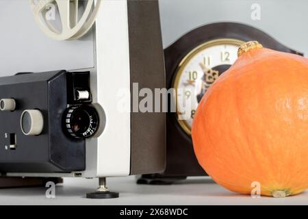 Concept de film d'Halloween. L'heure du film d'horreur. Projecteur de film, citrouille et horloge Banque D'Images